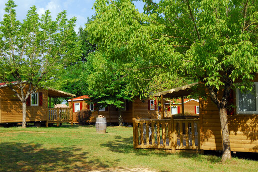 Mobil-homes de madera con terrazas sombreadas en el camping CAPFUN Hauts de Ratebout en STE FOY DE BELVES (24).