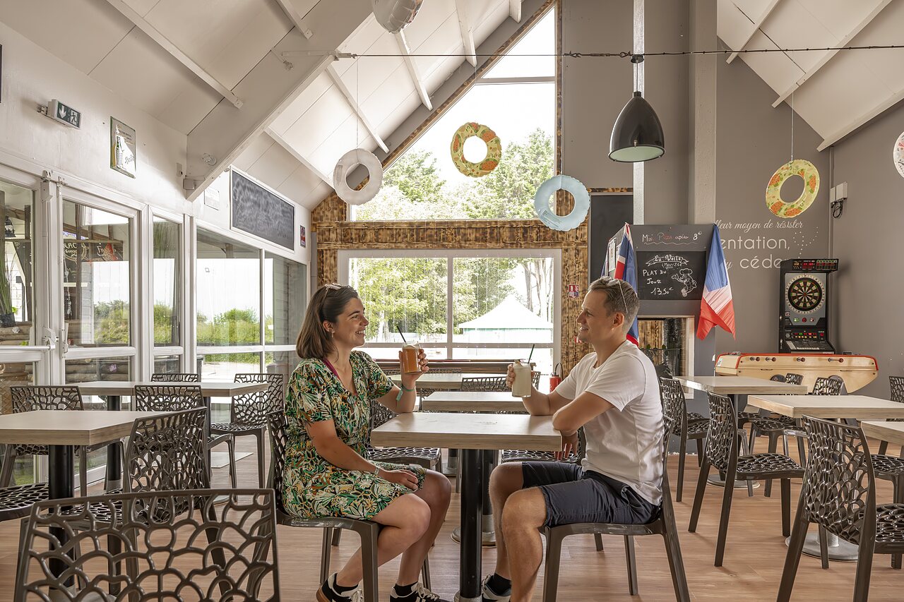 Pareja sonriente bebiendo en el bar del camping CLICOCHIC Havre de Berni�res.