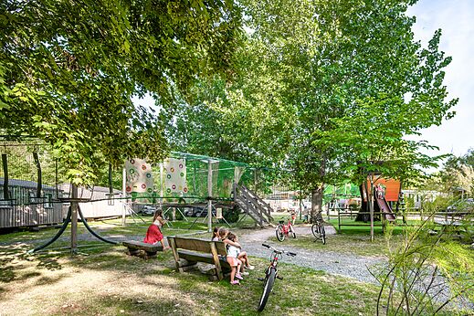 Zona de juegos con red de escalada, casa del �rbol y ni�os en camping CLICOCHIC Havre de Berni�res en Berni�res-sur-Mer (14).