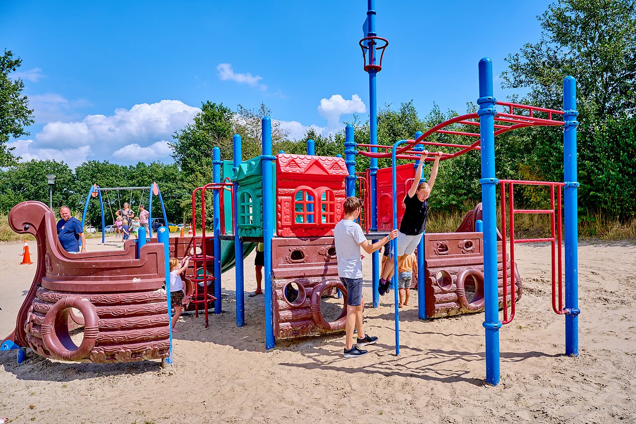 Zona de juegos colorida con estructuras, toboganes y columpios en el camping CAPFUN Heino.
