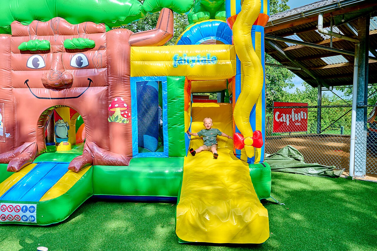 Ni�o en tobog�n hinchable gigante, �rea de juegos en el camping CAPFUN Heino.