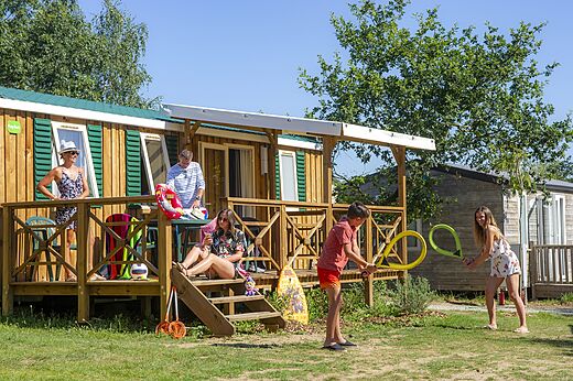 Familia de vacaciones frente a Mobil-home en camping CAPFUN Heino en Heino.