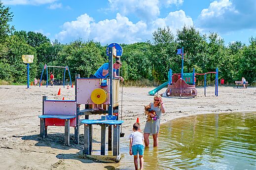 Zona de juegos de arena con estructuras y columpios en el camping CAPFUN Heino en Heino.