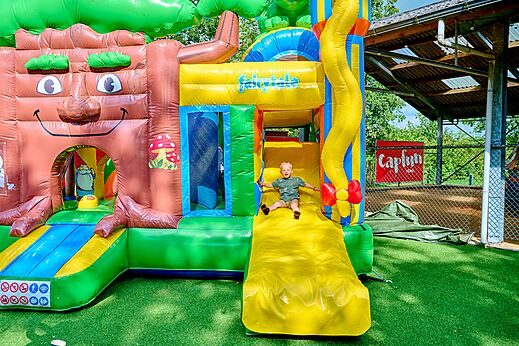 Niño en estructura hinchable gigante con tobogán en el camping CAPFUN Heino en Heino.