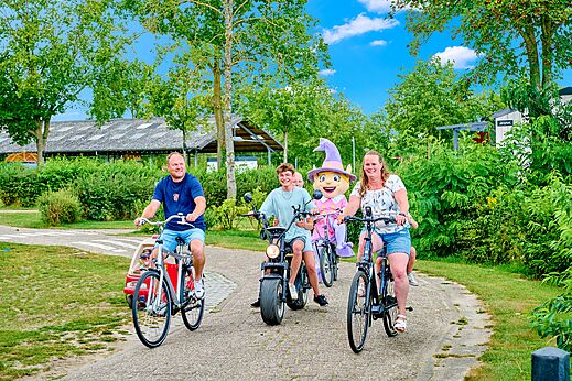 Familia en bicicleta con mascota y vehículos variados en el camping CAPFUN Heino en Heino.