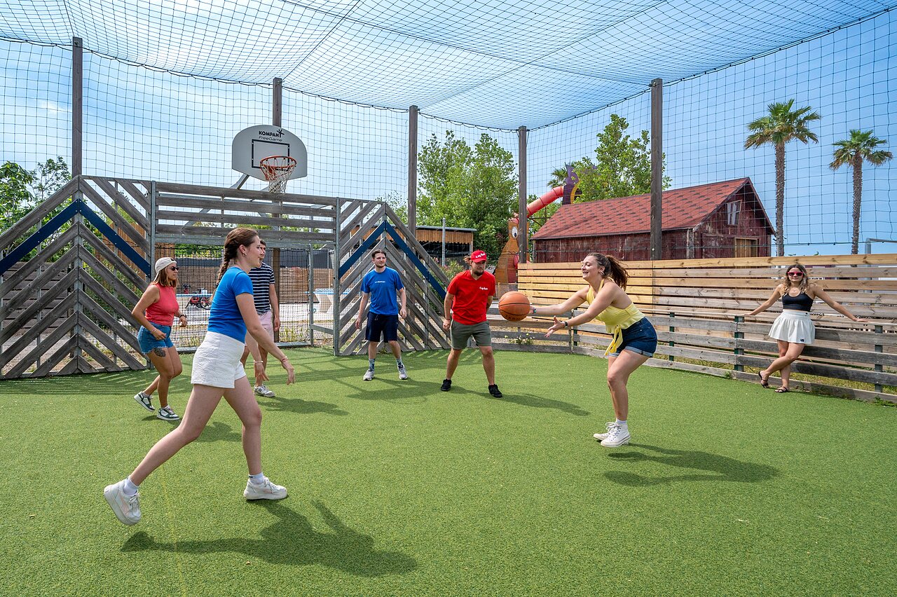 Pista multideporte con j�venes jugando baloncesto en el camping CAPFUN Hermitage en SERIGNAN (34).