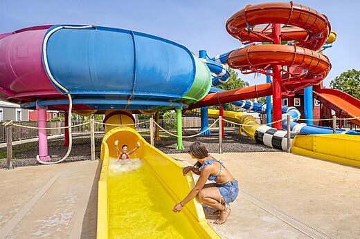 Toboganes acuáticos coloridos con niños en el camping CAPFUN Hermitage en SERIGNAN (34).