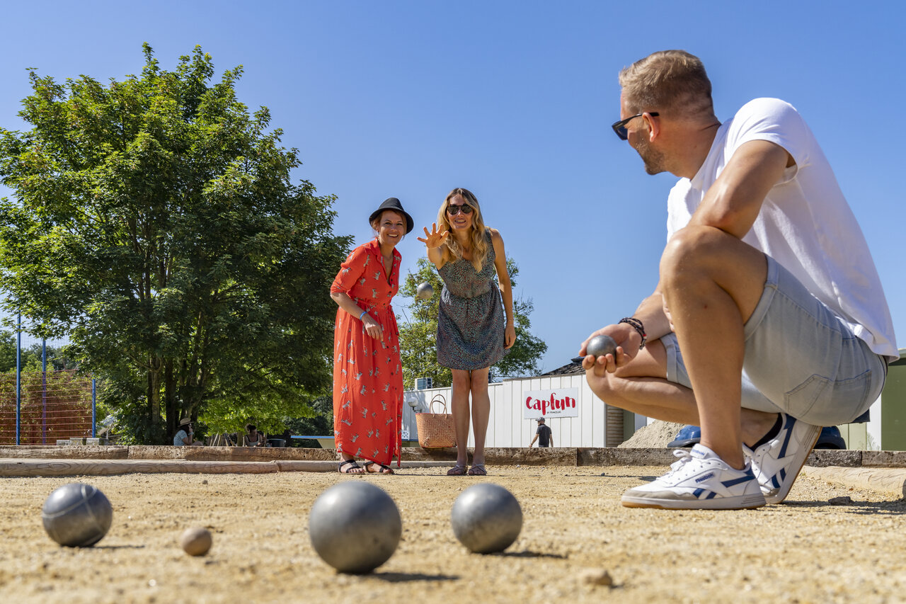 Familia jugando a la petanca en el camping CAPFUN Hirondelle en Oteppe.