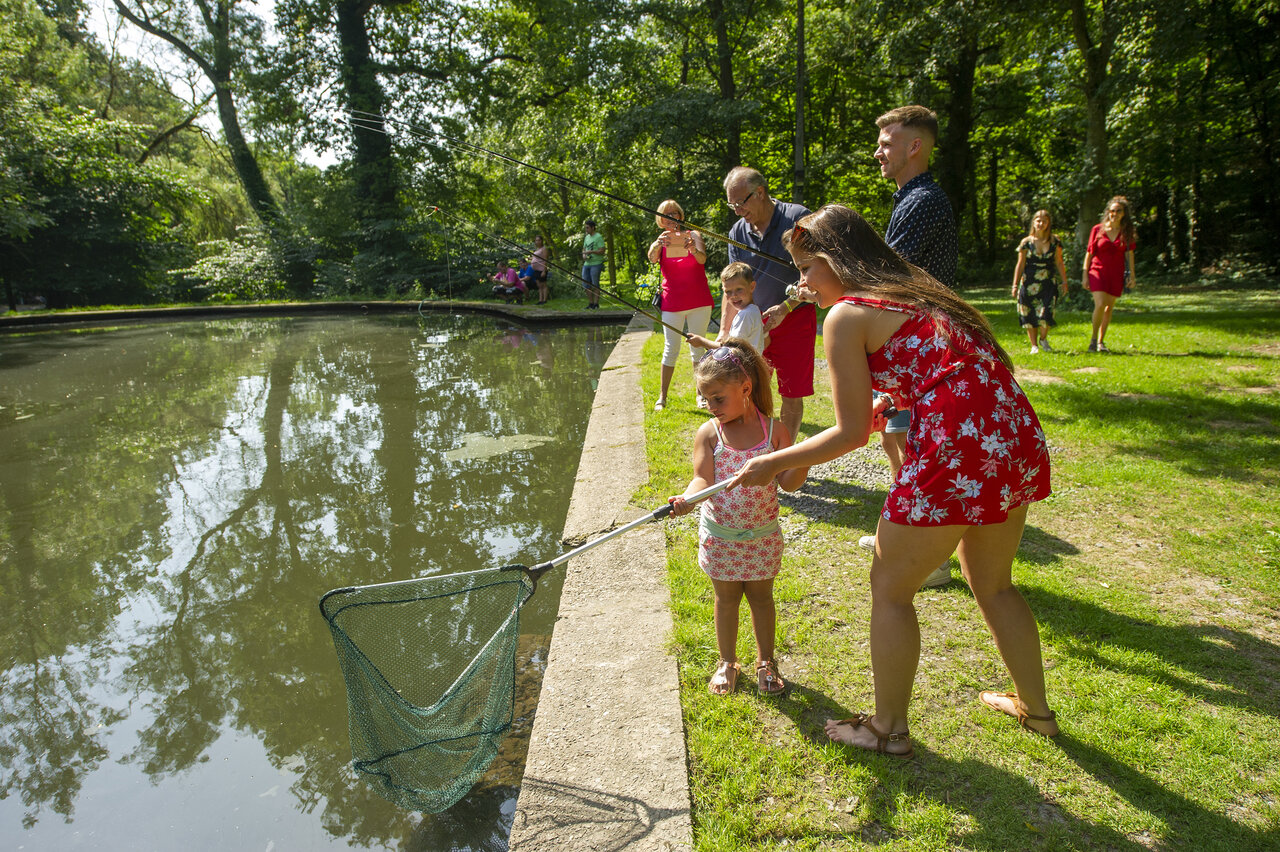 Familia pescando con red en el estanque del camping CAPFUN Hirondelle en Oteppe.