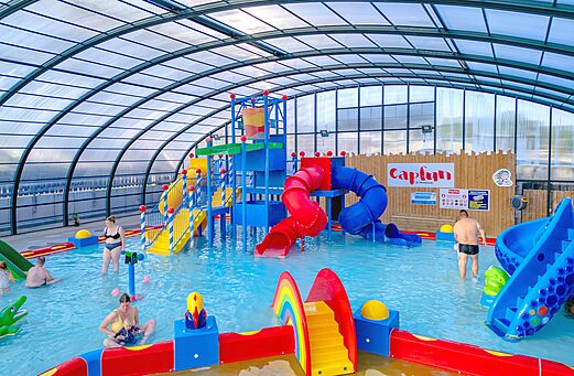 Piscina cubierta con toboganes acu�ticos y juegos de agua en el camping CAPFUN Hirondelle en Oteppe.
