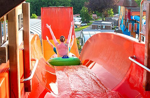 Persona en flotador bajando un gran tobog�n acu�tico en el camping CAPFUN Hirondelle en Oteppe.