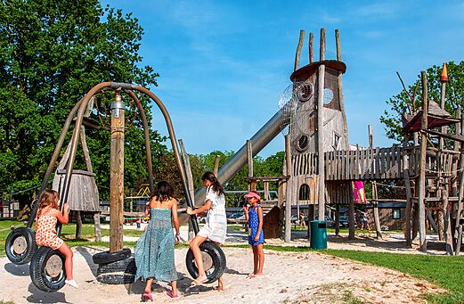 Gran parque infantil de madera con tobog�n y columpios en el camping CAPFUN Hirondelle en Oteppe.