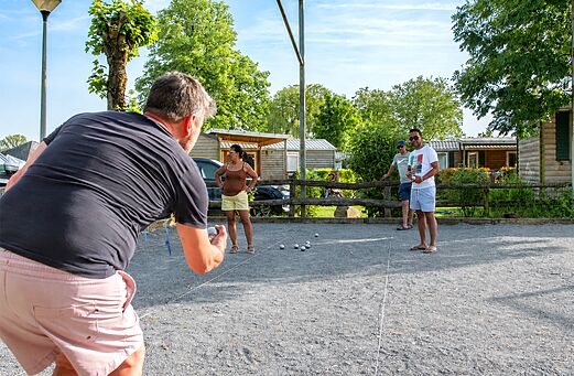 Campo de petanca con veraneantes jugando a las bolas en el camping CAPFUN Hirondelle en Oteppe.