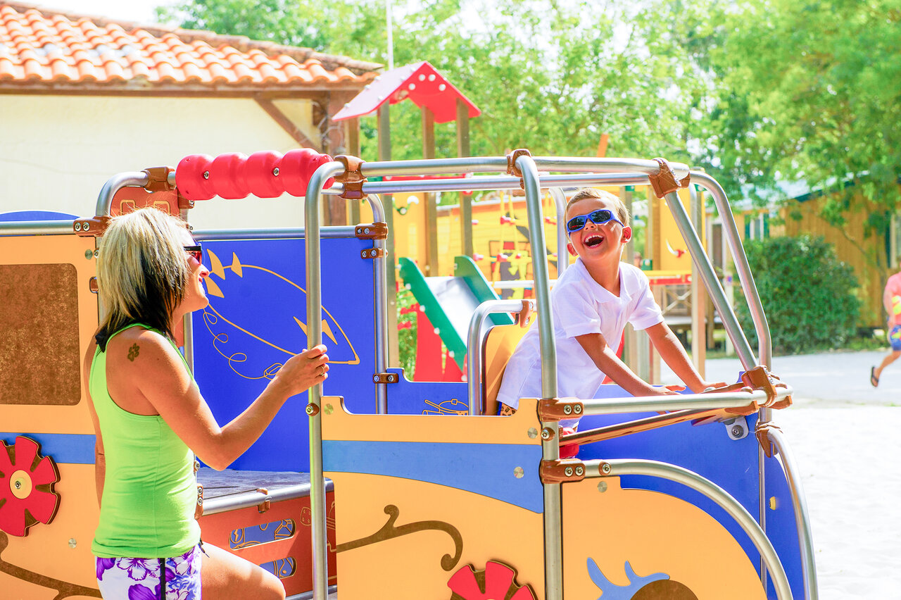 Parque infantil colorido, ni�o y mujer sonrientes, camping CAPFUN Huttes, Saint-Denis d'Ol�ron.