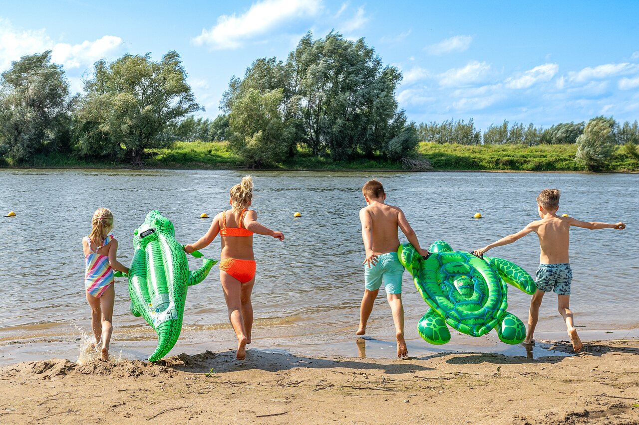 Ni�os con flotadores en playa de arena, camping CAPFUN IJsselstrand en Doesburg.