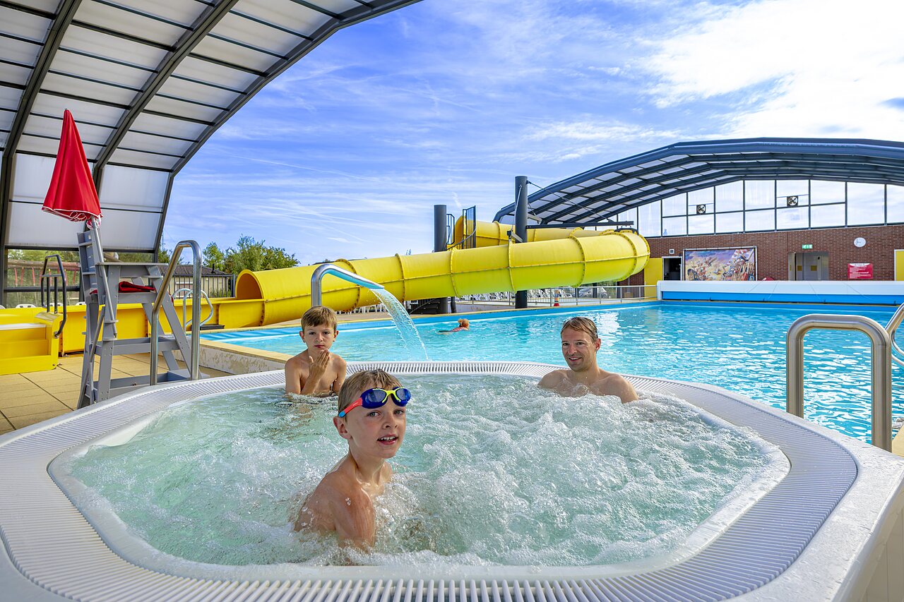 Familia en el jacuzzi, tobog�n acu�tico gigante en el camping CAPFUN IJsselstrand en Doesburg.