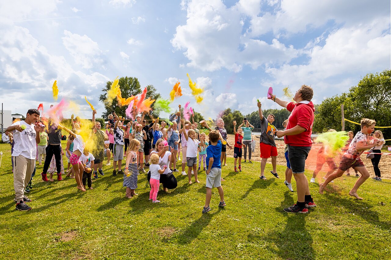 Ni�os y adultos disfrutando de animaci�n con polvos de colores en camping CAPFUN IJsselstrand en Doesburg.