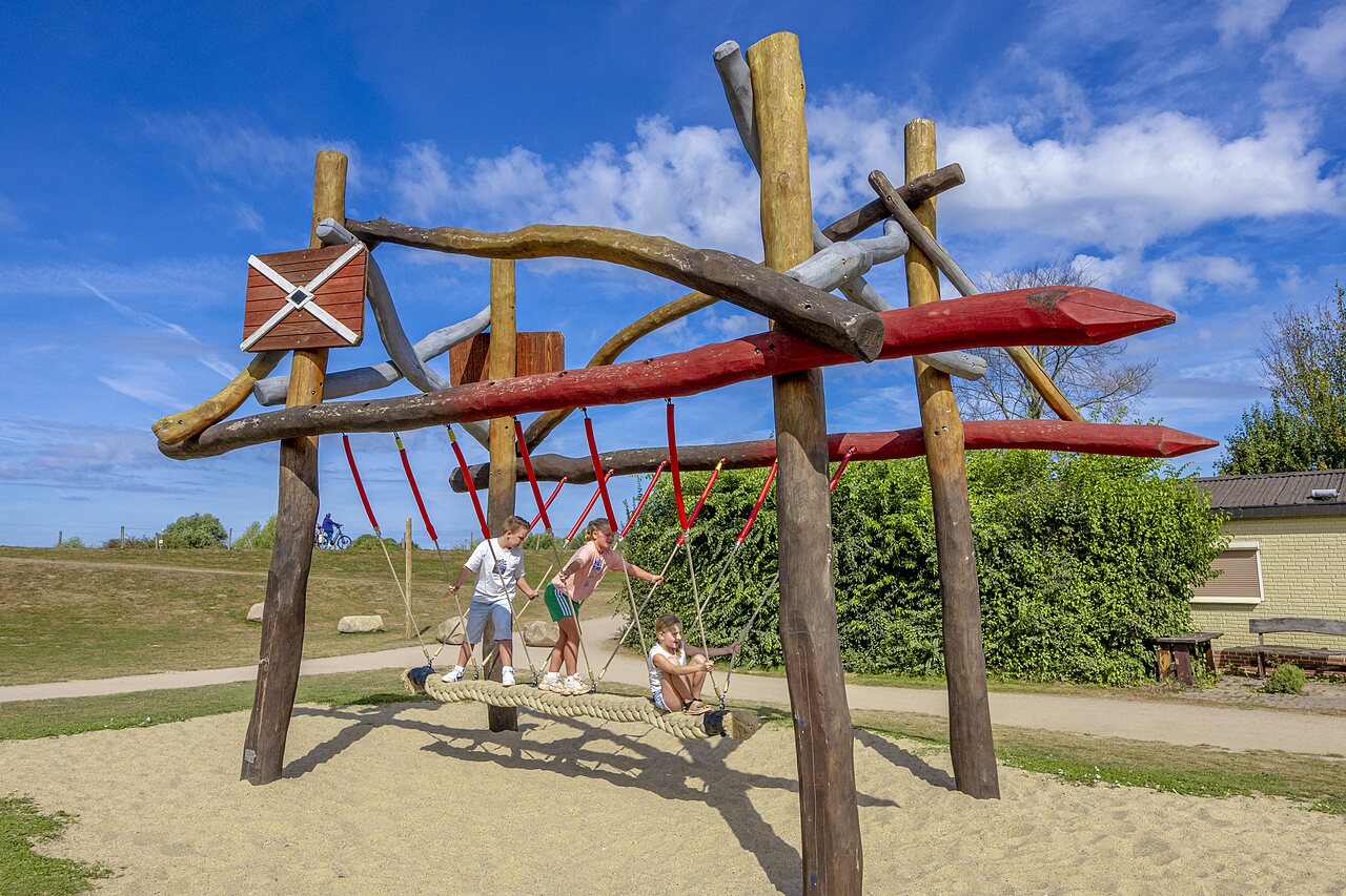 Ni�os jugando en estructura de juegos de madera y cuerdas en camping CAPFUN IJsselstrand en Doesburg.
