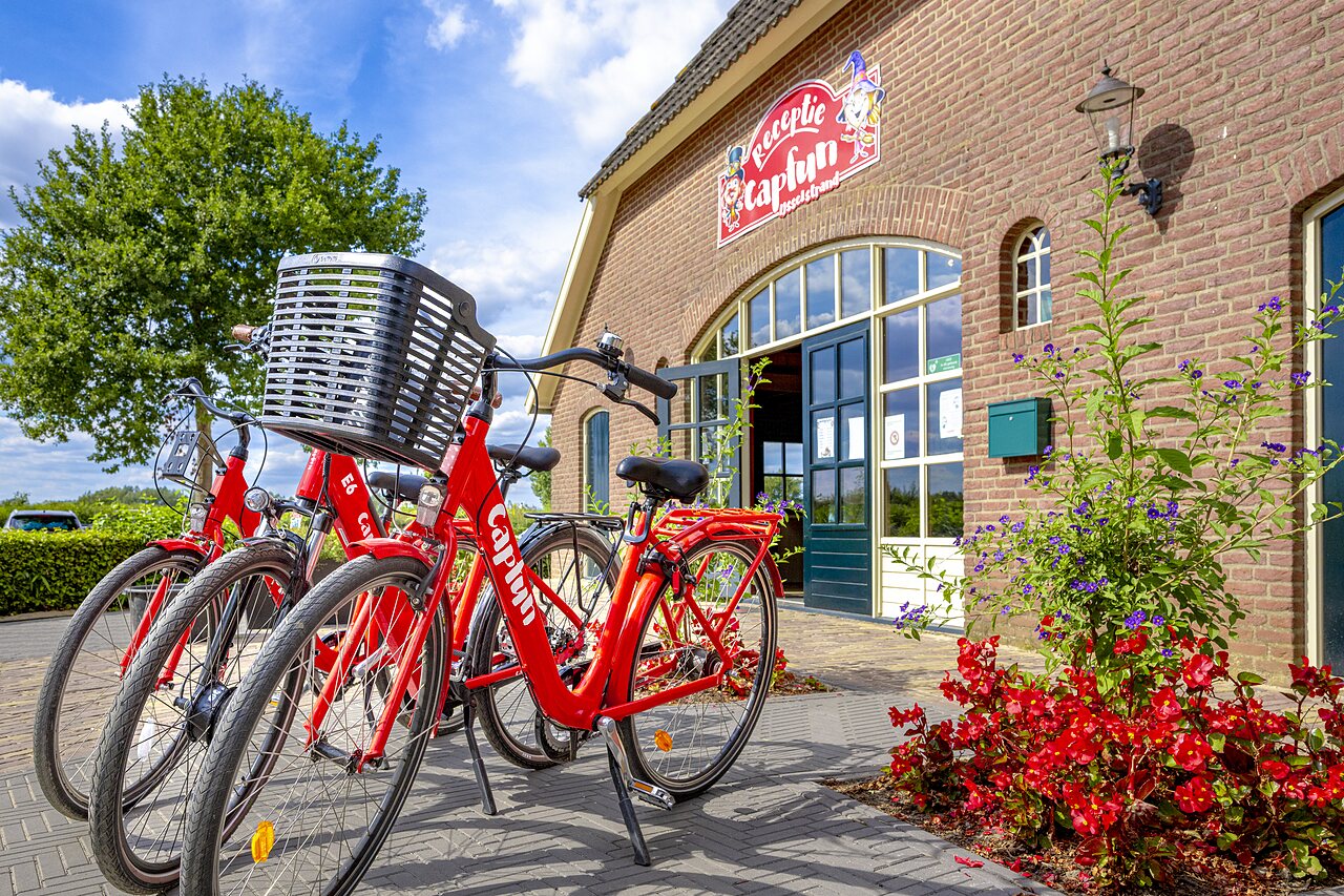 Bicicletas rojas de alquiler frente a la recepci�n del camping CAPFUN IJsselstrand en Doesburg.