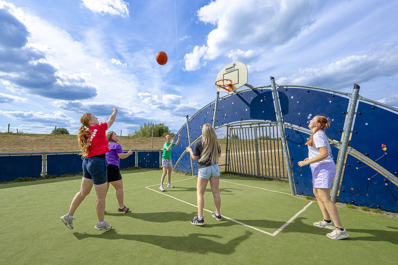 J�venes jugando baloncesto en cancha multideporte al camping CAPFUN IJsselstrand en Doesburg.