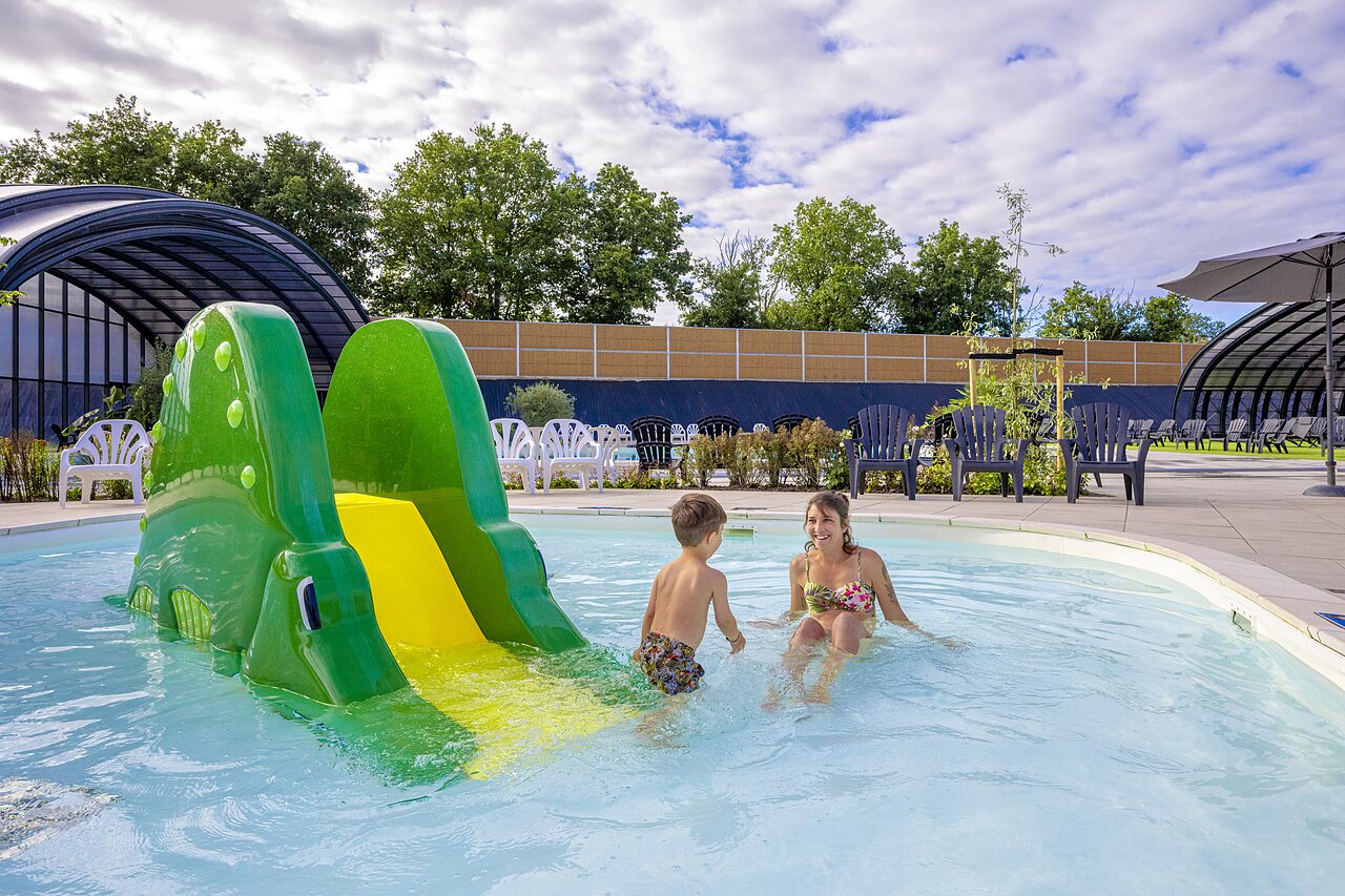 Piscina exterior con tobog�n cocodrilo, madre e hijo en el CAPFUN IJsselstrand Doesburg.