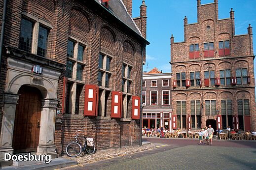Calle histórica de Doesburg con edificios de ladrillo y terrazas animadas.