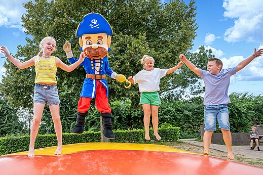 Ni�os y mascota pirata saltando en coj�n hinchable en el camping CAPFUN IJsselstrand en Doesburg.
