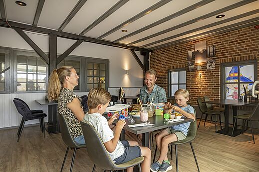Familia cenando en el restaurante del camping CAPFUN IJsselstrand en Doesburg.