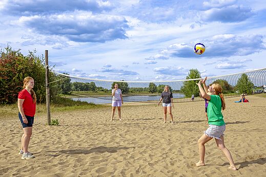 Jugadores de voleibol en la playa de arena en el camping CAPFUN IJsselstrand en Doesburg.