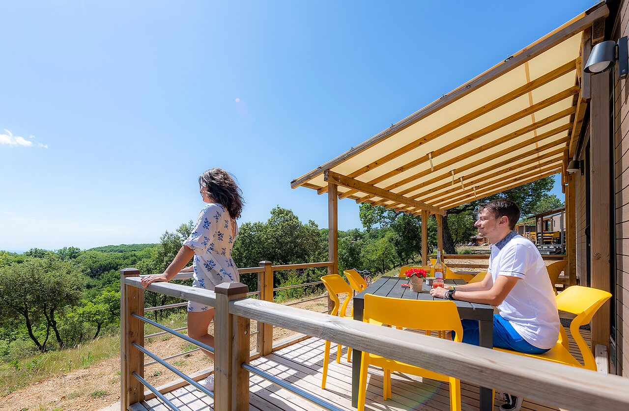 Terraza de mobil-home con vista a la naturaleza, pareja relaj�ndose, CAPFUN Imbours en LARNAS (07).