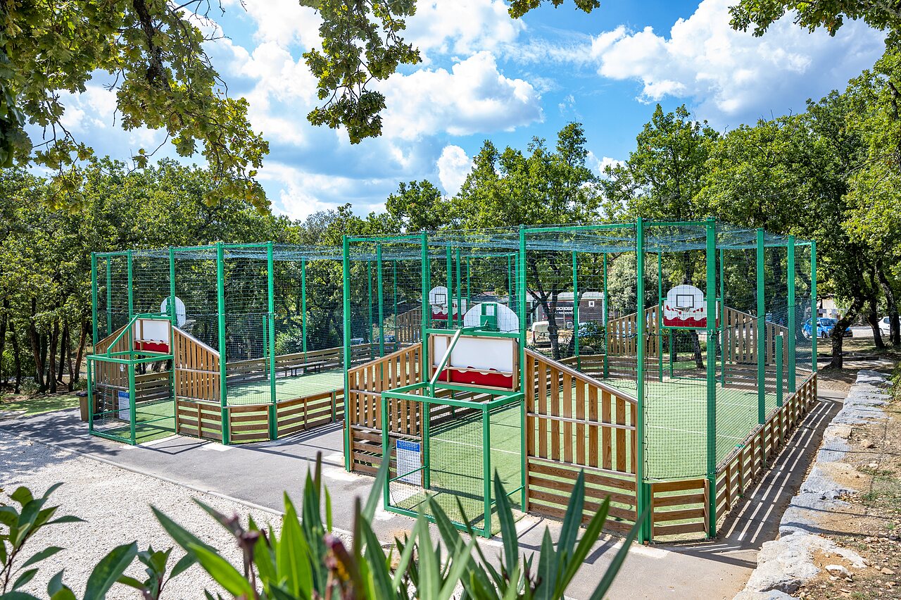 Cancha multideporte con varias canastas de baloncesto en el camping CAPFUN Imbours en LARNAS (07).