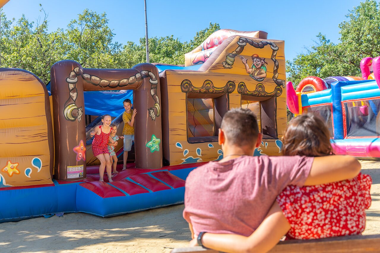 Zona de juegos hinchable pirata con ni�os sonrientes en el camping CAPFUN Imbours en LARNAS (07).