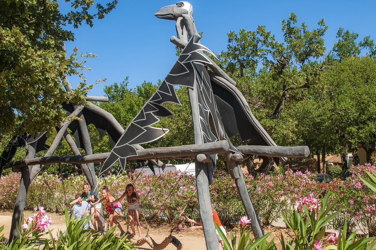 Estructura de juegos drag�n con ni�os en columpios en el camping CAPFUN Imbours en LARNAS (07).