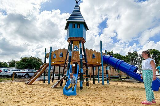 Zona de juegos con tobogán y torre de madera en el camping CAPFUN Imbours en LARNAS (07).