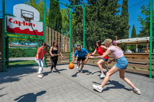 Campo multideportivo con adultos jugando baloncesto en el camping CAPFUN Jantou en LE THOR (84).