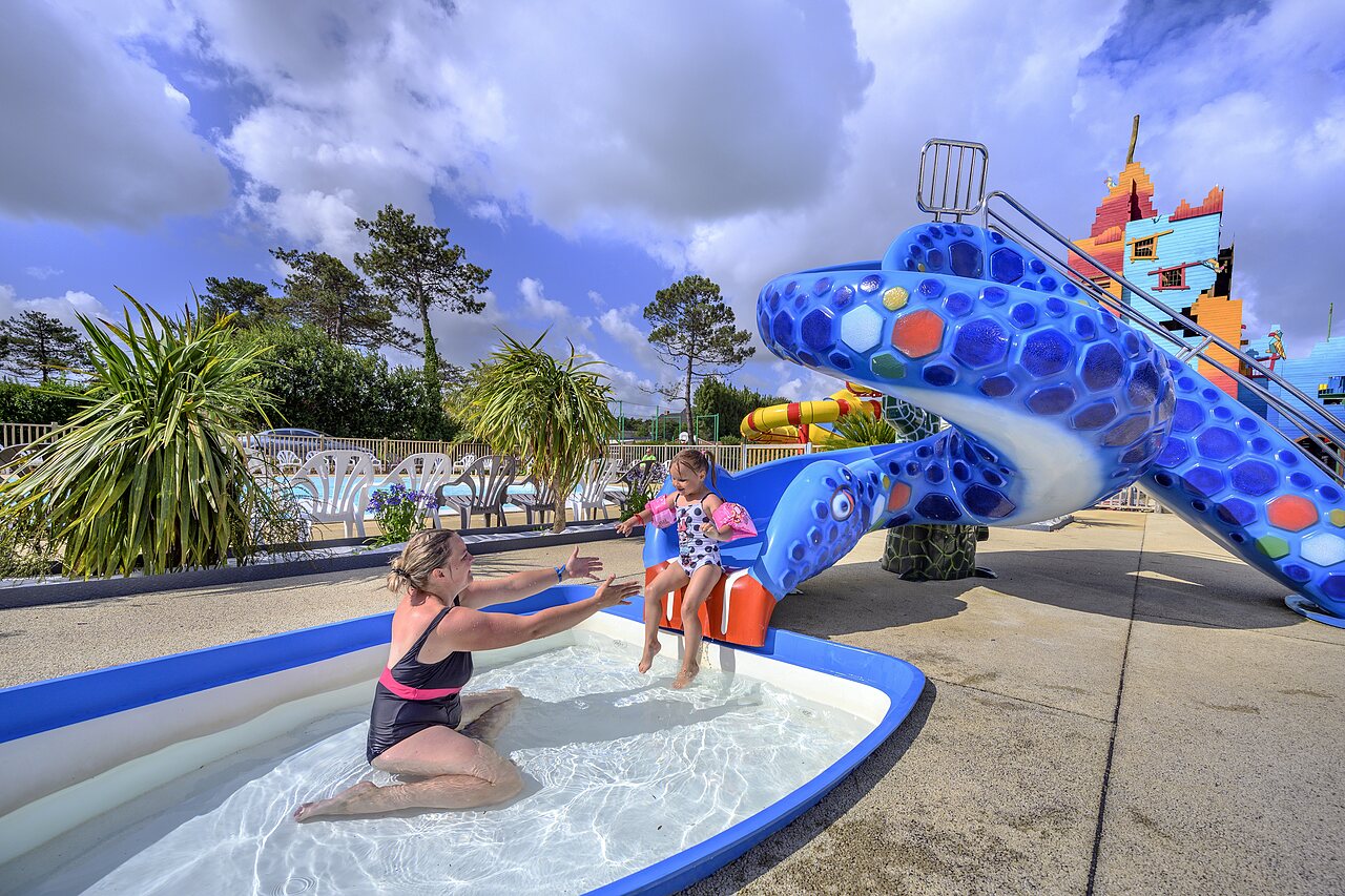 Ni�a en tobog�n tortuga, piscina infantil y madre en camping CAPFUN Joncal en Grandcamp - Maisy.