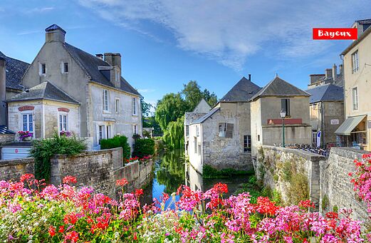 Canal florido y casas históricas en Bayeux, ciudad encantadora de Normandía.