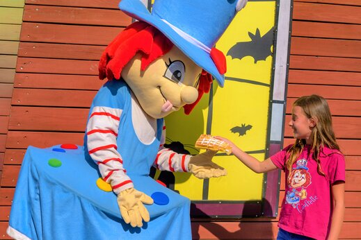 Mascota y ni�a compartiendo un gofre, animaci�n en el camping CAPFUN Kervel en PLONEVEZ PORZAY (29).