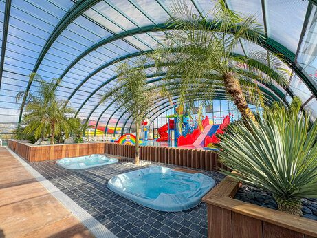 Piscina cubierta con toboganes y jacuzzis en el camping CAPFUN Kervel en PLONEVEZ PORZAY (29).