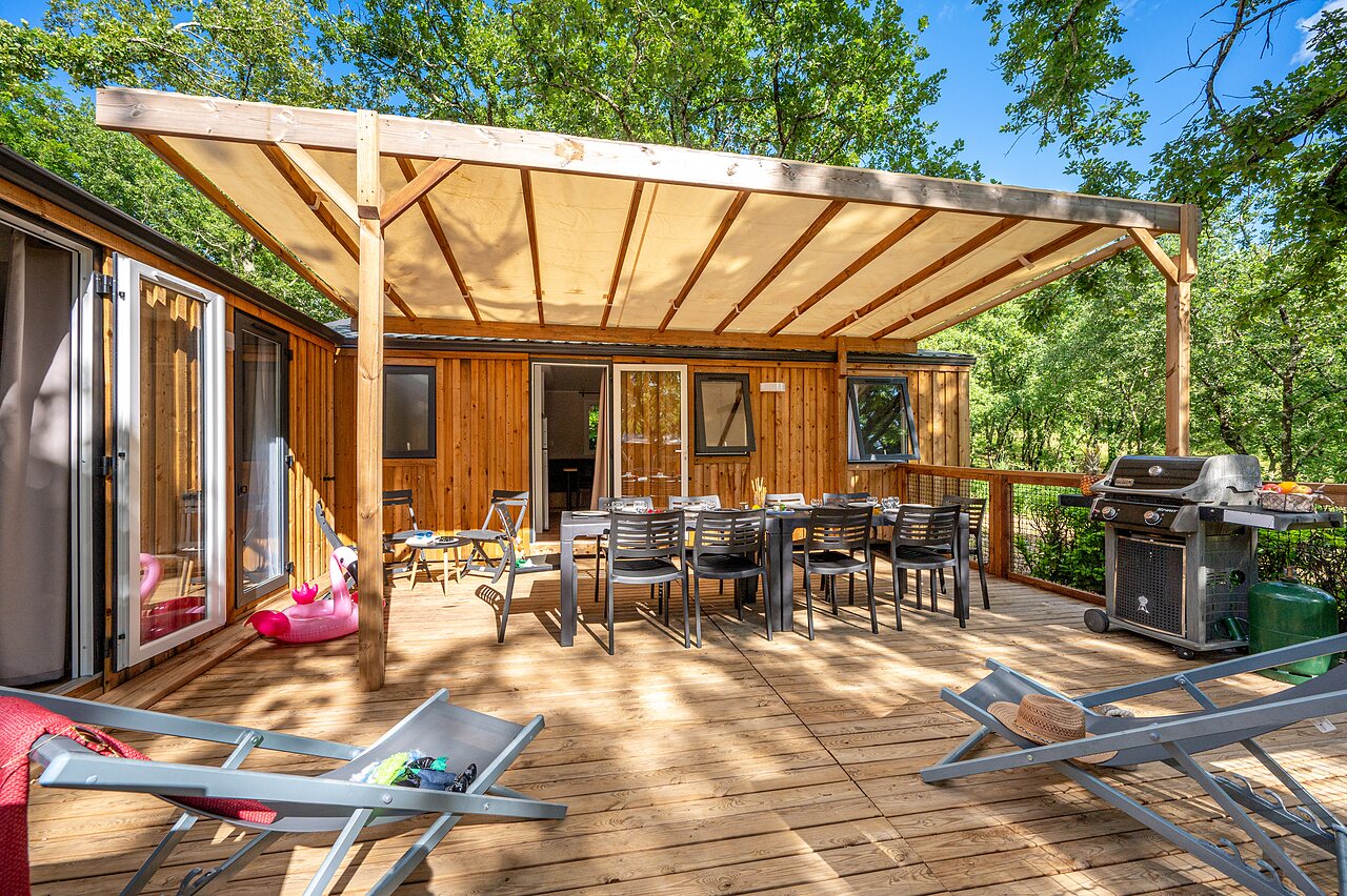 Amplia terraza cubierta, barbacoa y mobil-home en camping VAGUES OCEANES Labeiller en Saint Victor de Malcap (30).