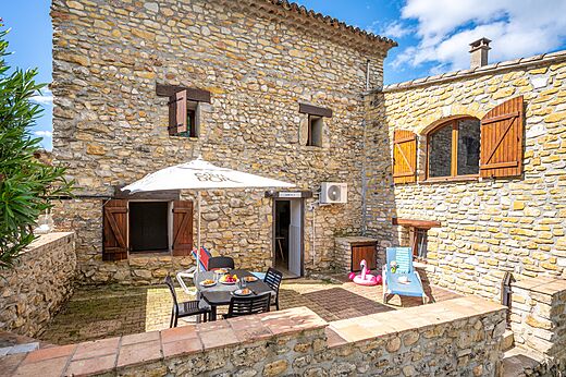 Alojamiento de piedra con terraza y mesa en el camping VAGUES OCEANES Labeiller en Saint Victor de Malcap (30).