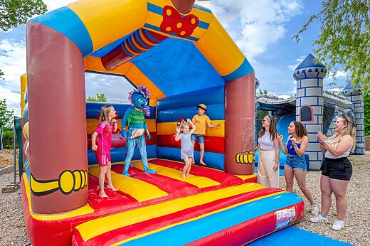 Juego hinchable colorido, niños y animador en el camping VAGUES OCEANES Labeiller en Saint Victor de Malcap (30).