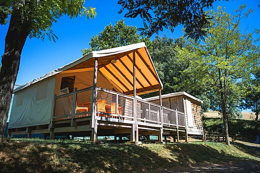 Tienda lodge con terraza de madera en el camping CAPFUN Lac des 3 Vall�es en Lectoure (32).