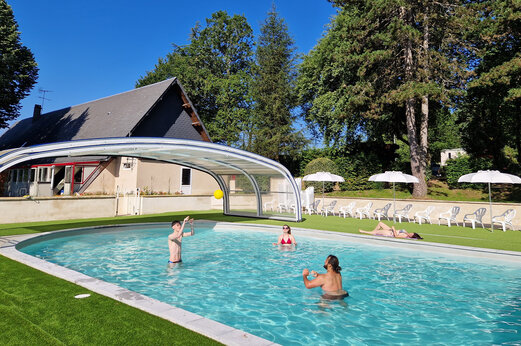 Piscina con cubierta, familia jugando a la pelota en camping CLICOCHIC Lac de Miel.