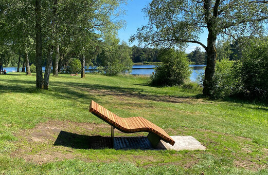 Tumbona de madera junto al lago, camping CLICOCHIC Lac de Miel.