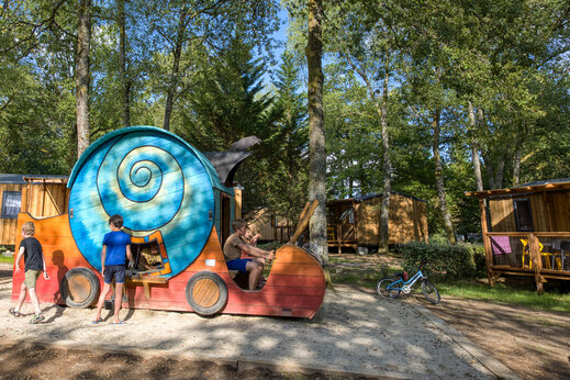 Niños jugando en estructura de caracol, Mobil-homes en camping CLICOCHIC Lac de Miel en Beynat (19).