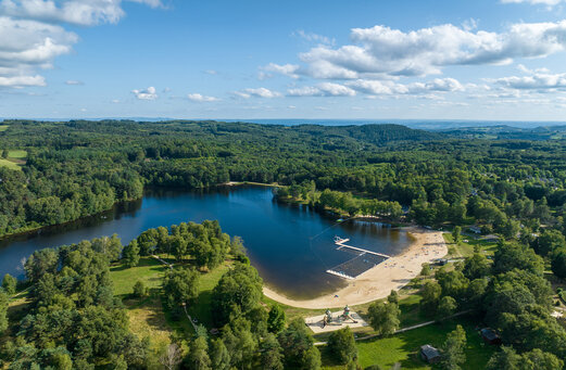 Lago, playa de arena y zona de baño, vista aérea en el camping CLICOCHIC Lac de Miel en Beynat (19).