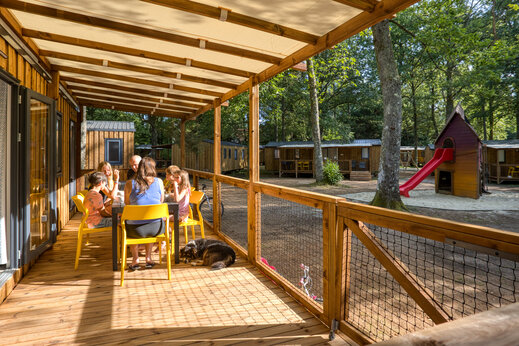 Familia en terraza de Mobil-home en camping CLICOCHIC Lac de Miel en Beynat (19).