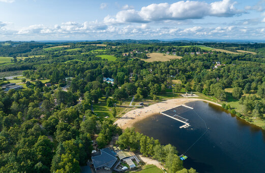 Playa de arena y lago en el camping CLICOCHIC Lac de Miel en Beynat.