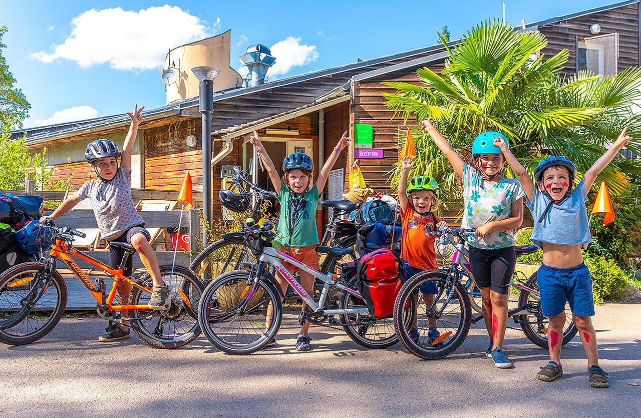 Ni�os en bicicleta frente a la recepci�n del camping VAGUES OCEANES Lac de Panthier.